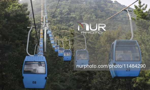 Tourists are riding ropeways at Lianhua Mountain in Dalian, China, on August 15, 2024. 