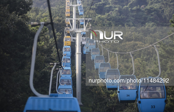 Tourists are riding ropeways at Lianhua Mountain in Dalian, China, on August 15, 2024. 