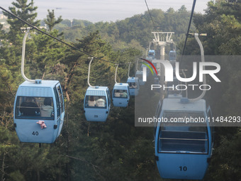 Tourists are riding ropeways at Lianhua Mountain in Dalian, China, on August 15, 2024. (