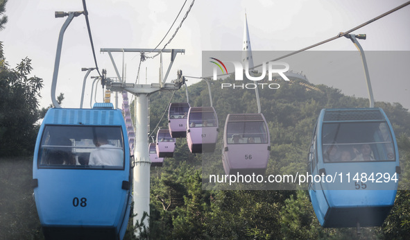 Tourists are riding ropeways at Lianhua Mountain in Dalian, China, on August 15, 2024. 