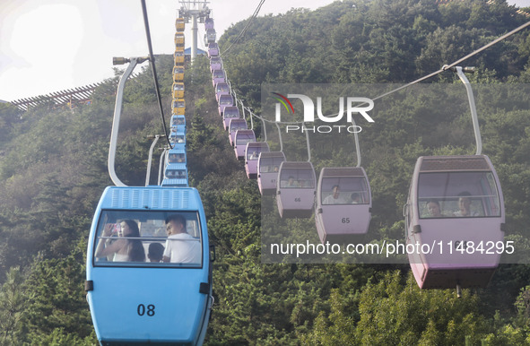 Tourists are riding ropeways at Lianhua Mountain in Dalian, China, on August 15, 2024. 