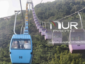 Tourists are riding ropeways at Lianhua Mountain in Dalian, China, on August 15, 2024. (