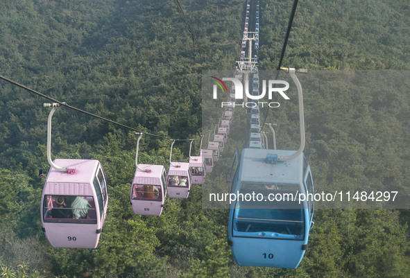 Tourists are riding ropeways at Lianhua Mountain in Dalian, China, on August 15, 2024. 