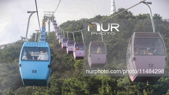 Tourists are riding ropeways at Lianhua Mountain in Dalian, China, on August 15, 2024. 