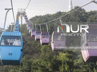 Tourists are riding ropeways at Lianhua Mountain in Dalian, China, on August 15, 2024. (