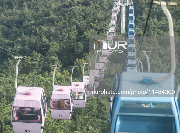 Tourists are riding ropeways at Lianhua Mountain in Dalian, China, on August 15, 2024. 