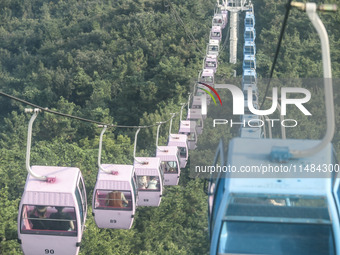 Tourists are riding ropeways at Lianhua Mountain in Dalian, China, on August 15, 2024. (