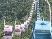 Tourists are riding ropeways at Lianhua Mountain in Dalian, China, on August 15, 2024. (