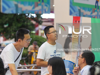 Job seekers are looking for information at a night market recruitment fair in Sanmenxia, China, on August 16, 2024. (