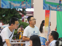 Job seekers are looking for information at a night market recruitment fair in Sanmenxia, China, on August 16, 2024. (