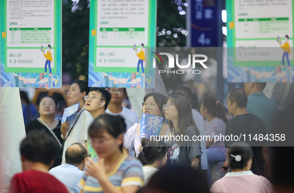 Job seekers are looking for information at a night market recruitment fair in Sanmenxia, China, on August 16, 2024. 