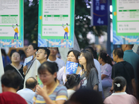 Job seekers are looking for information at a night market recruitment fair in Sanmenxia, China, on August 16, 2024. (