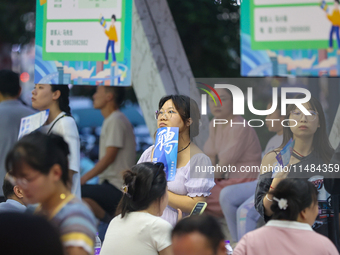 Job seekers are looking for information at a night market recruitment fair in Sanmenxia, China, on August 16, 2024. (