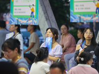 Job seekers are looking for information at a night market recruitment fair in Sanmenxia, China, on August 16, 2024. (