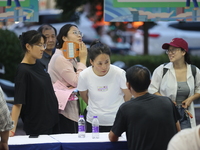 Job seekers are looking for information at a night market recruitment fair in Sanmenxia, China, on August 16, 2024. (