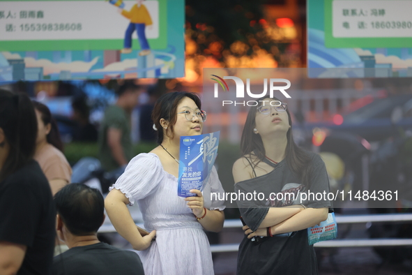 Job seekers are looking for information at a night market recruitment fair in Sanmenxia, China, on August 16, 2024. 