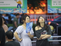 Job seekers are looking for information at a night market recruitment fair in Sanmenxia, China, on August 16, 2024. (