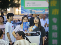 Job seekers are looking for information at a night market recruitment fair in Sanmenxia, China, on August 16, 2024. (