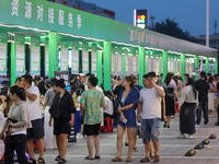 Job seekers are looking for information at a night market recruitment fair in Sanmenxia, China, on August 16, 2024. (