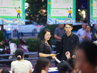 Job seekers are looking for information at a night market recruitment fair in Sanmenxia, China, on August 16, 2024. (