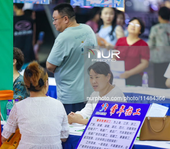 Job seekers are looking for information at a night market recruitment fair in Sanmenxia, China, on August 16, 2024. 