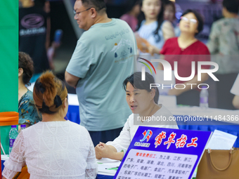 Job seekers are looking for information at a night market recruitment fair in Sanmenxia, China, on August 16, 2024. (