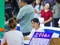 Job seekers are looking for information at a night market recruitment fair in Sanmenxia, China, on August 16, 2024. (