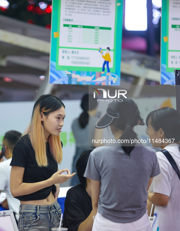 Job seekers are looking for information at a night market recruitment fair in Sanmenxia, China, on August 16, 2024. 