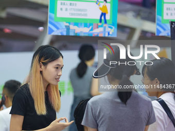 Job seekers are looking for information at a night market recruitment fair in Sanmenxia, China, on August 16, 2024. (