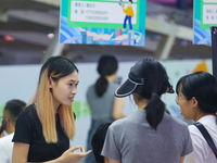 Job seekers are looking for information at a night market recruitment fair in Sanmenxia, China, on August 16, 2024. (