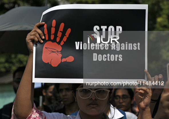 Medical professionals are shouting slogans and holding placards to protest against the rape and murder of a trainee medic at a government-ru...