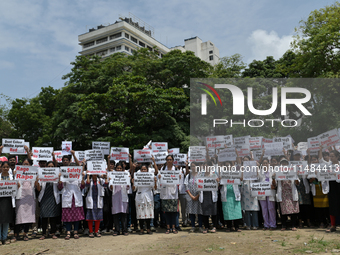 Medical professionals are shouting slogans and holding placards to protest against the rape and murder of a trainee medic at a government-ru...