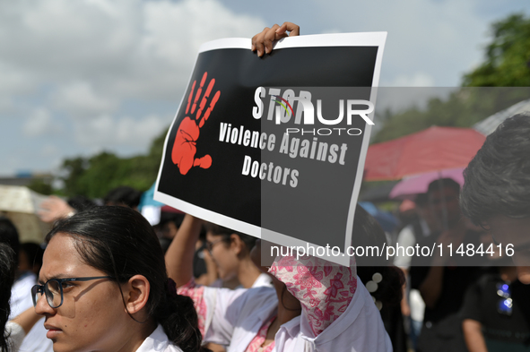 Medical professionals are shouting slogans and holding placards to protest against the rape and murder of a trainee medic at a government-ru...