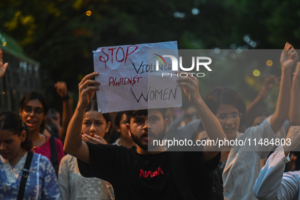 A protestor is holding a placard in a protest by medical professionals condemning the rape and murder of a trainee medic at a hospital in Ko...