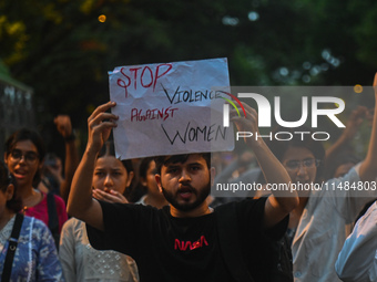 A protestor is holding a placard in a protest by medical professionals condemning the rape and murder of a trainee medic at a hospital in Ko...