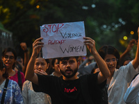 A protestor is holding a placard in a protest by medical professionals condemning the rape and murder of a trainee medic at a hospital in Ko...