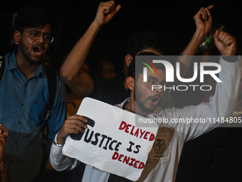 Medical professionals and students are shouting slogans in a protest condemning the rape and murder of a trainee medic at a hospital in Kolk...