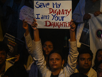 A medical professional is holding a placard in a protest condemning the rape and murder of a trainee medic at a hospital in Kolkata, in fron...