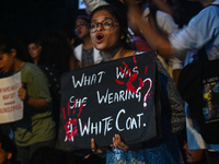 A medical professional is holding a placard in a protest condemning the rape and murder of a trainee medic at a hospital in Kolkata, in fron...