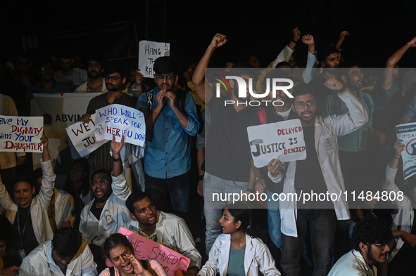 Medical professionals and students are shouting slogans in a protest condemning the rape and murder of a trainee medic at a hospital in Kolk...