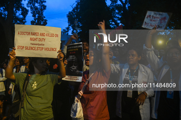 Medical professionals and students are shouting slogans in a protest condemning the rape and murder of a trainee medic at a hospital in Kolk...