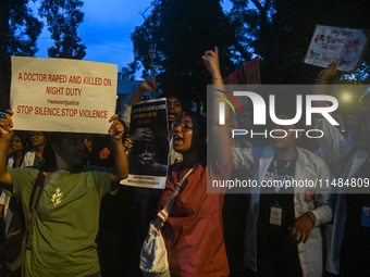 Medical professionals and students are shouting slogans in a protest condemning the rape and murder of a trainee medic at a hospital in Kolk...