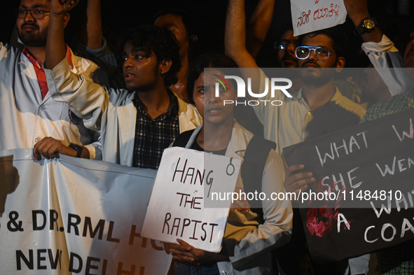 Medical professionals and students are holding placards in a protest condemning the rape and murder of a trainee medic at a hospital in Kolk...