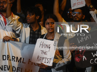 Medical professionals and students are holding placards in a protest condemning the rape and murder of a trainee medic at a hospital in Kolk...