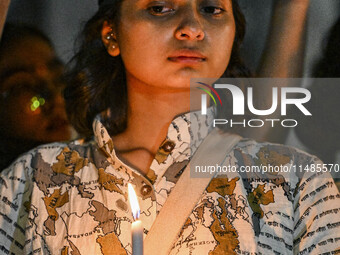 A Bangladeshi woman protester is holding a candlelight during the protest against rape in Dhaka, Bangladesh, on August 17, 2024. Women are m...