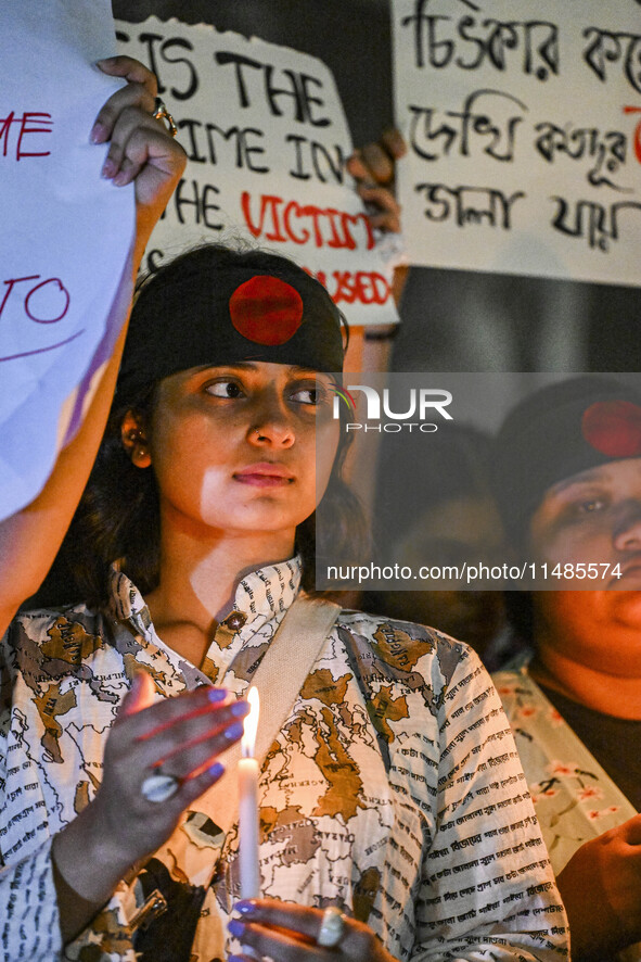 A Bangladeshi woman protester is holding a candlelight during the protest against rape in Dhaka, Bangladesh, on August 17, 2024. Women are m...