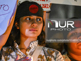 A Bangladeshi woman protester is holding a candlelight during the protest against rape in Dhaka, Bangladesh, on August 17, 2024. Women are m...