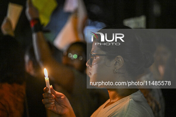 A Bangladeshi woman protester is holding a candlelight during the protest against rape in Dhaka, Bangladesh, on August 17, 2024. Women are m...