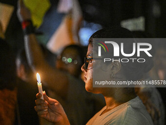 A Bangladeshi woman protester is holding a candlelight during the protest against rape in Dhaka, Bangladesh, on August 17, 2024. Women are m...