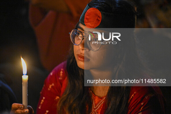 A Bangladeshi woman protester is holding a candlelight during the protest against rape in Dhaka, Bangladesh, on August 17, 2024. Women are m...